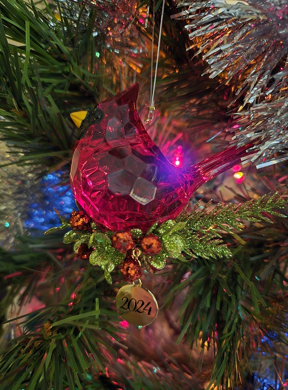 A Christmas ornament featuring a Northern Cardinal bird and the year 2024.