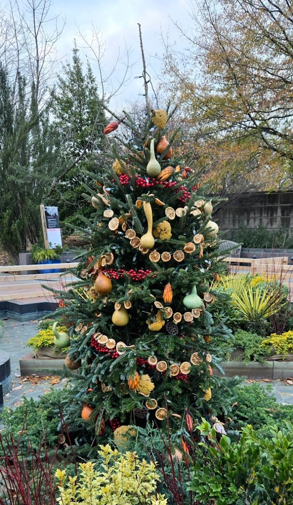 An outdoor Christmas tree decorated with fruits and vegetables.