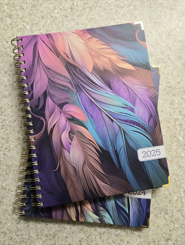 Two dayplanners, 2024 beneath 2025.