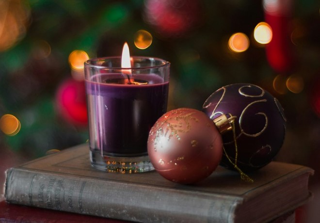 Christmas ornaments and a candle on top of a book.